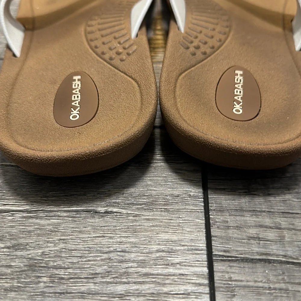 Okabashi flip flops with white straps and neutral color bottoms